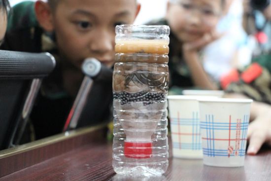 图为活动现场,小朋友观察自己搭建的“净水工厂”。主办方供图 图为活动现场,小朋友观察自己搭建的“净水工厂”。主办方供图