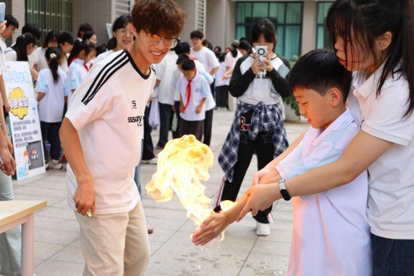 小朋友们在室外广场体验“火焰掌”实验。bw必威西汉姆联官方网站供图